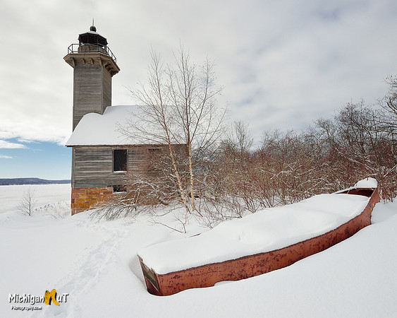 "Snow covered lighthouse and a boat full of snow"