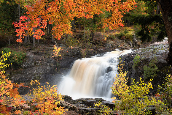 Sunkissed autumn leaves frame Dead River Falls, Marquette, Michigan